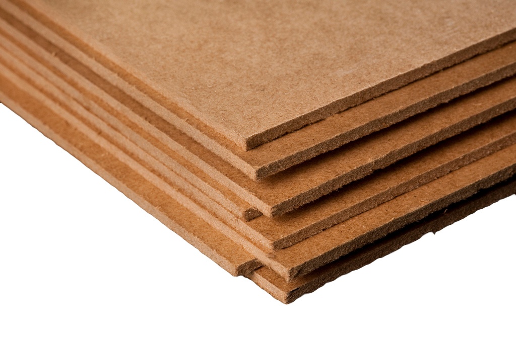 Bunt av skivor av MDF (medeldensitetfiberboard) i beige nyans staplade på varandra.